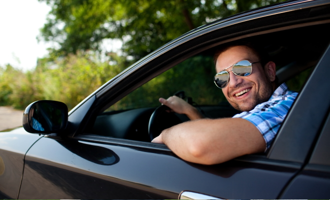 man smiling while driving car